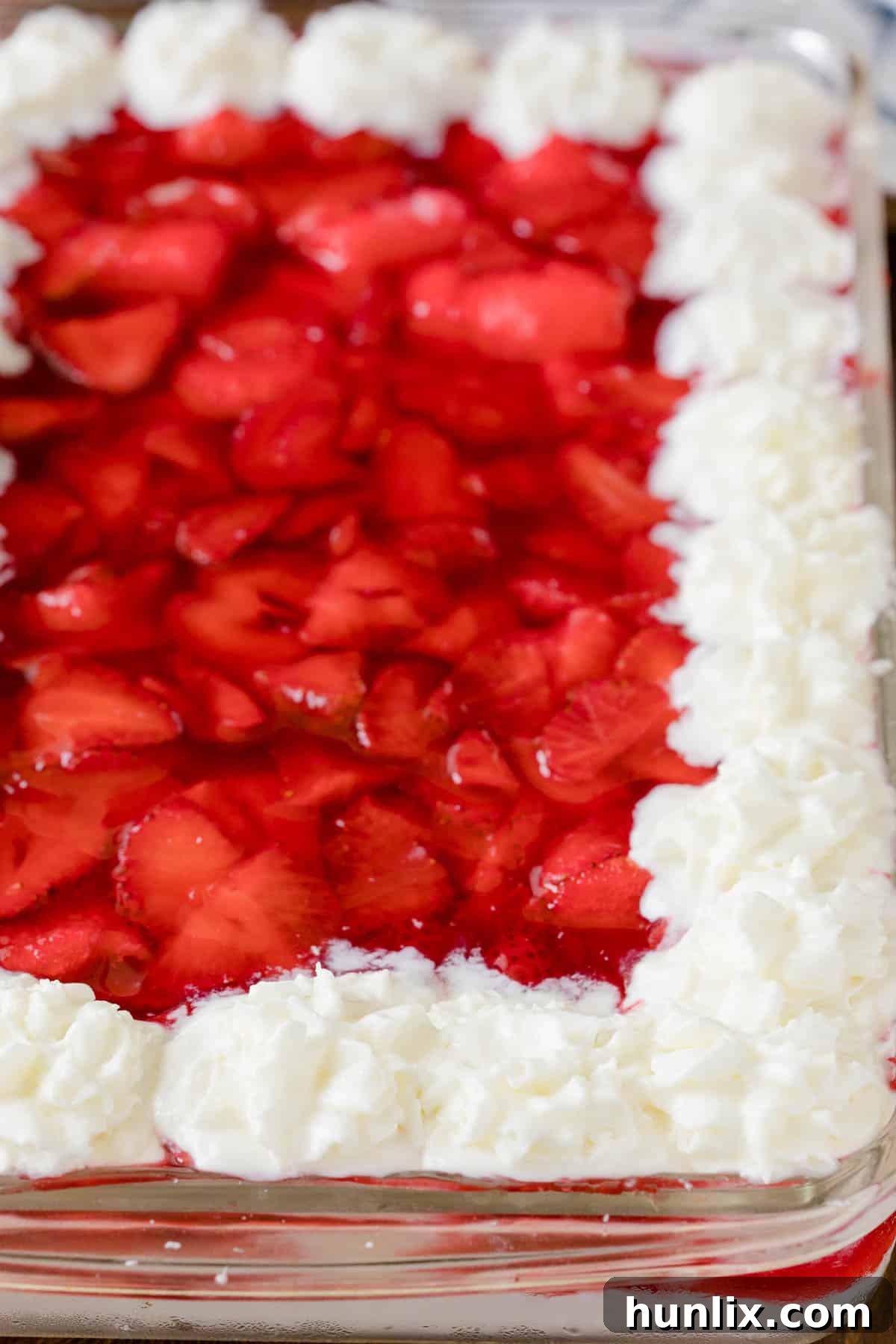 Close-up of Strawberries in the Snow in a casserole pan, showing layers of cake, cream, and strawberries.