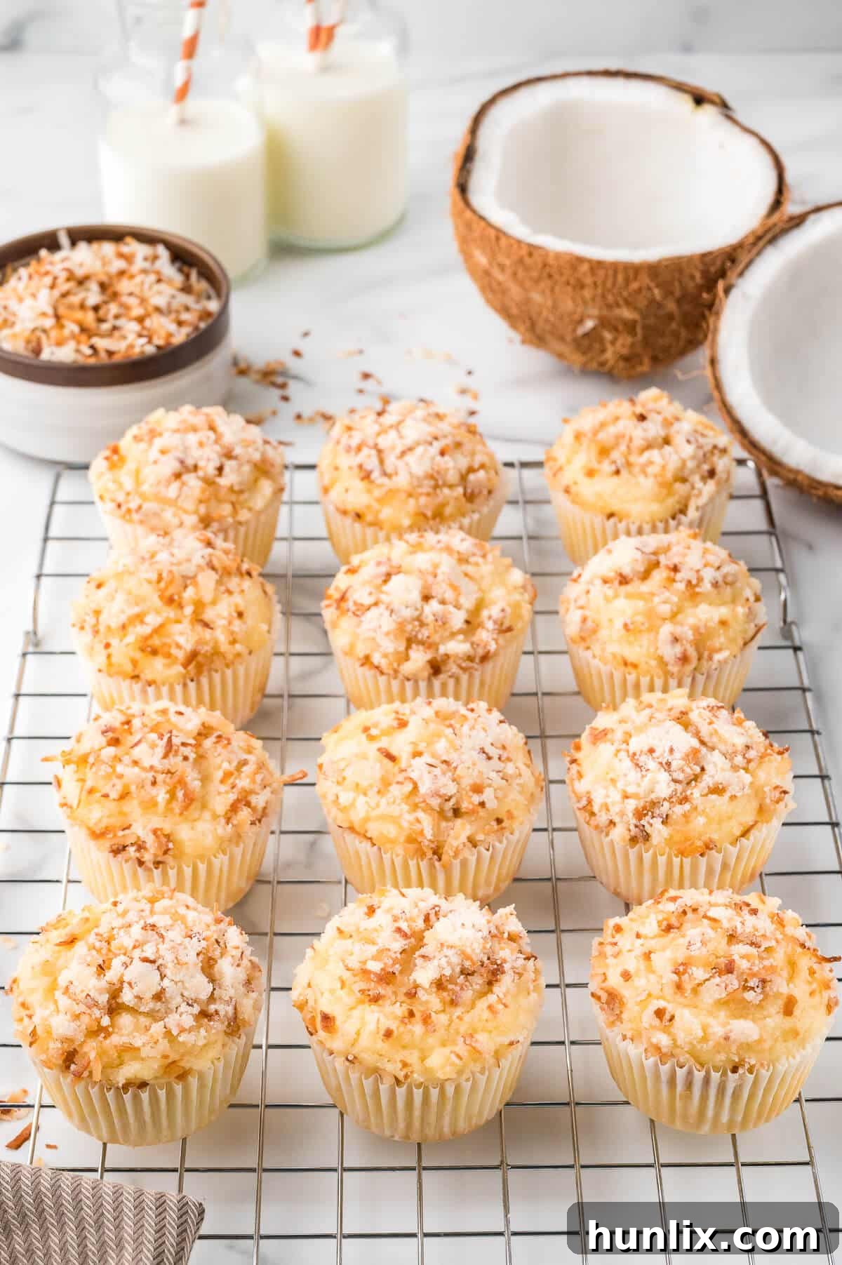 Freshly baked toasted coconut muffins cooling on a wire rack, showcasing their golden streusel topping.