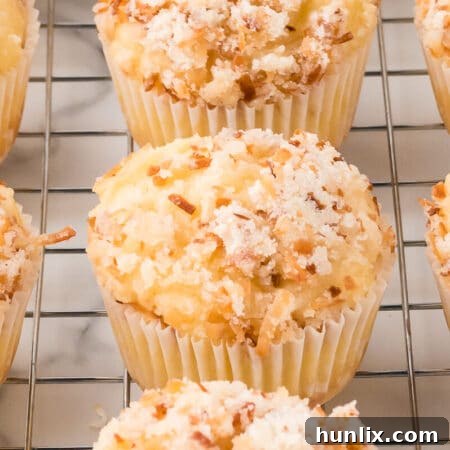 Toasted coconut muffins on a wire rack.