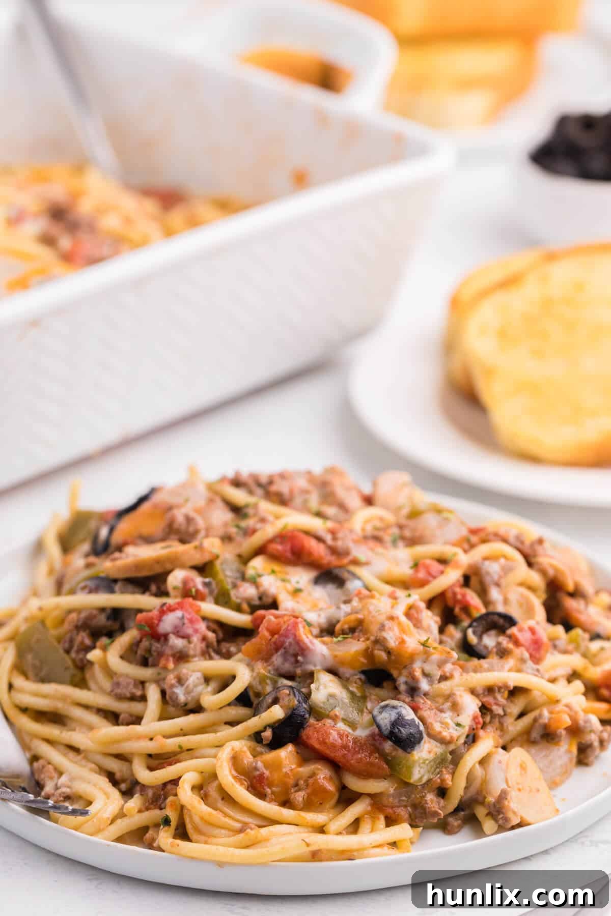 Hearty Spaghetti Bake 11 A close-up of a plate of spaghetti casserole, highlighting the layers of pasta, meat, and melted cheese, ready for a fork.