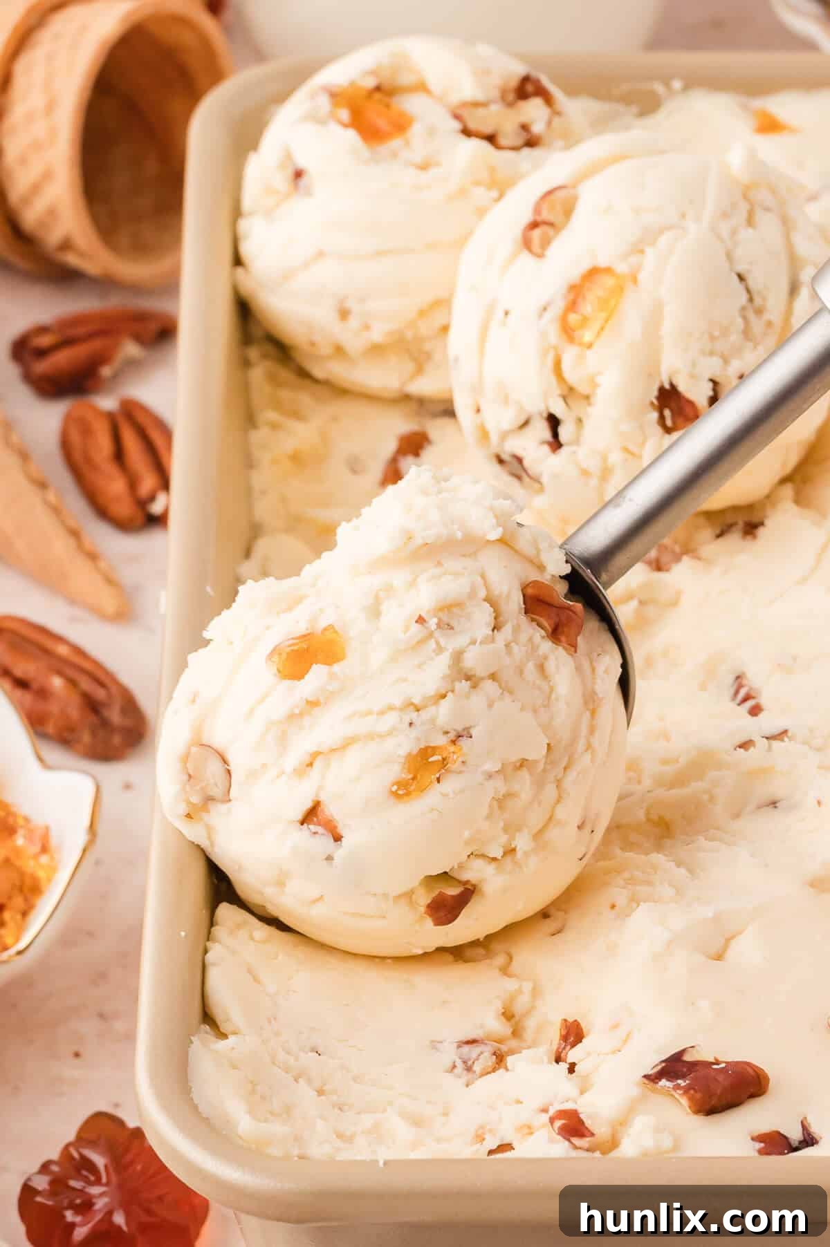 Maple Pecan Ice Cream Delight 2 Scoops of No-Churn Maple Pecan Ice Cream in a freezer-safe container, ready to be enjoyed.