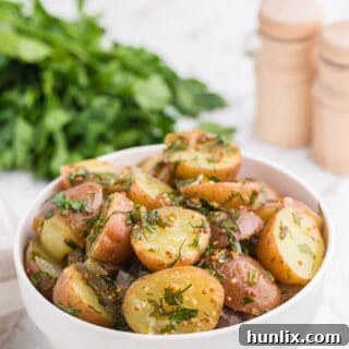 Vibrant Herb Potato Salad 6 Herb potato salad in a white bowl.