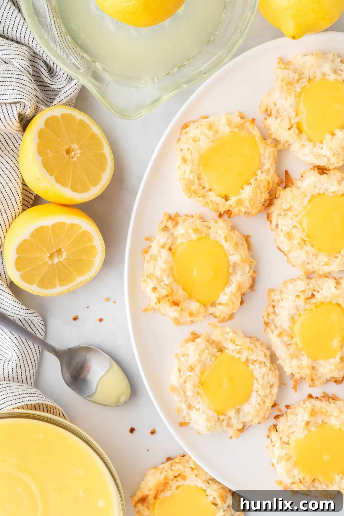 Several lemon curd coconut macaroons artfully arranged on a pristine white plate, showcasing their delightful appearance.