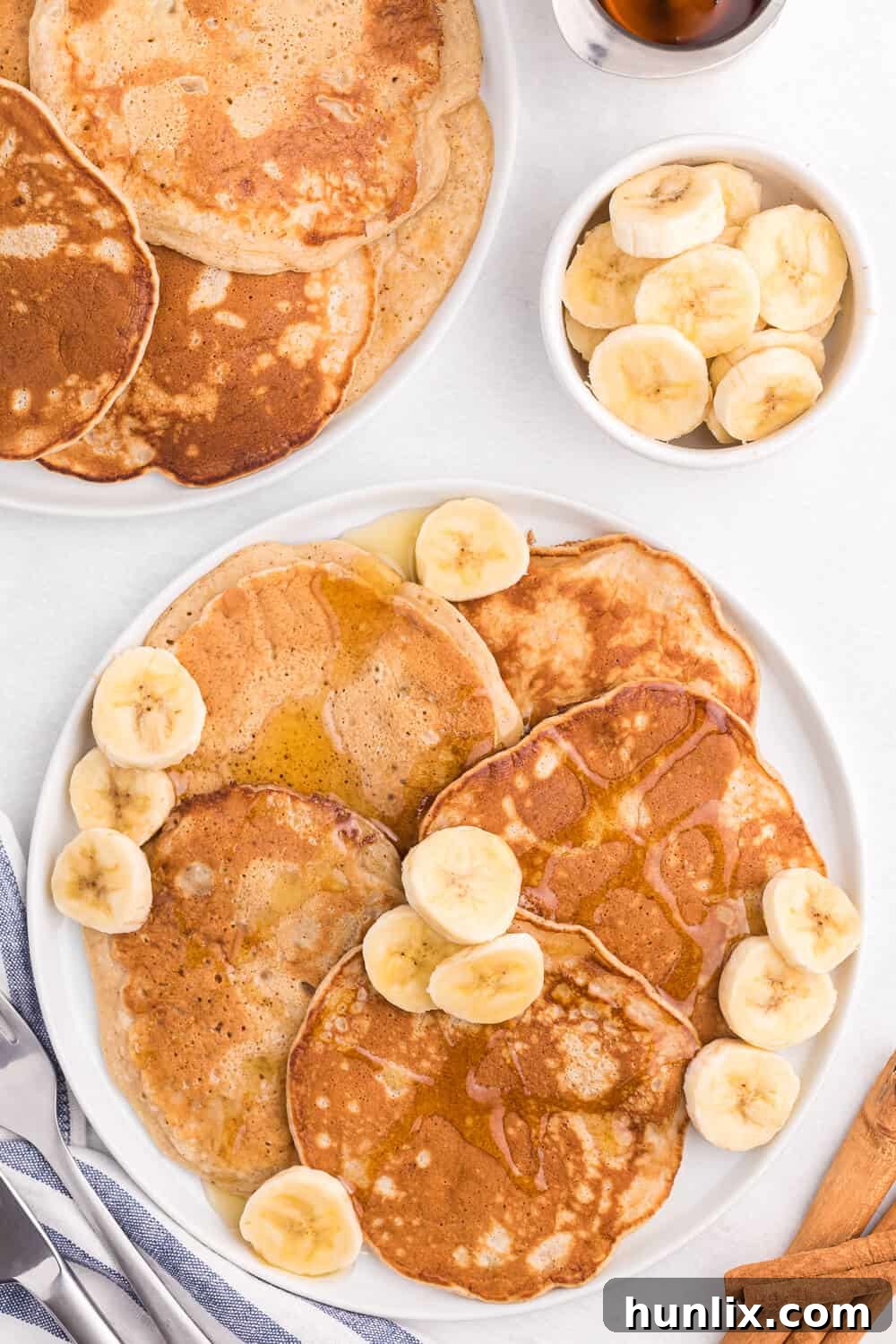 Deliciously fluffy cinnamon banana pancakes stacked high with syrup