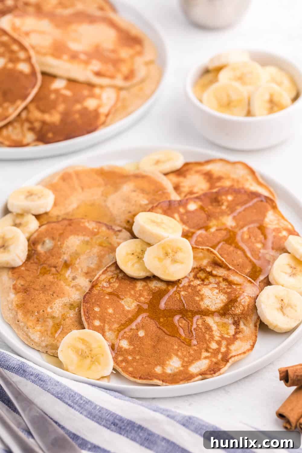 A stack of golden brown cinnamon banana pancakes ready to be served