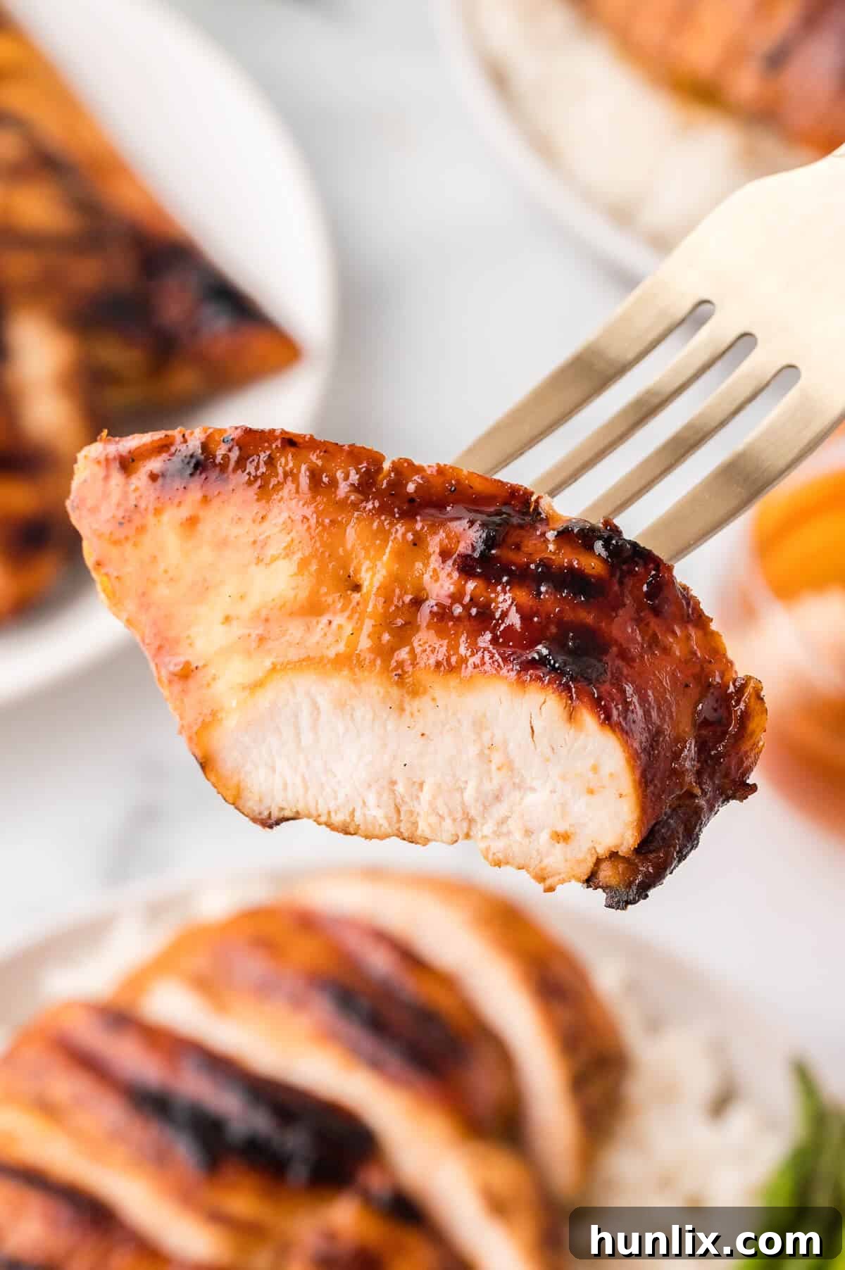 A piece of Ginger Lime Chicken on a fork, showing its juicy texture.