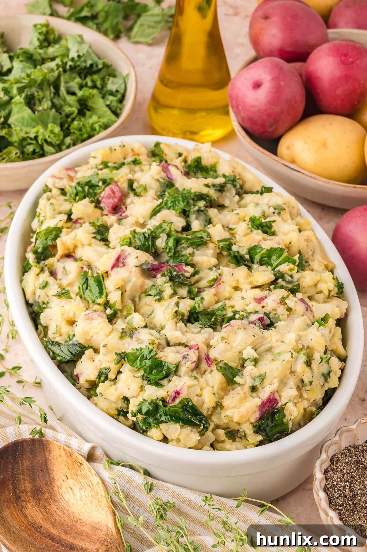 Vibrant Olive oil mashed potatoes with kale and herbs served in a rustic bowl on a wooden table, garnished with fresh herbs.