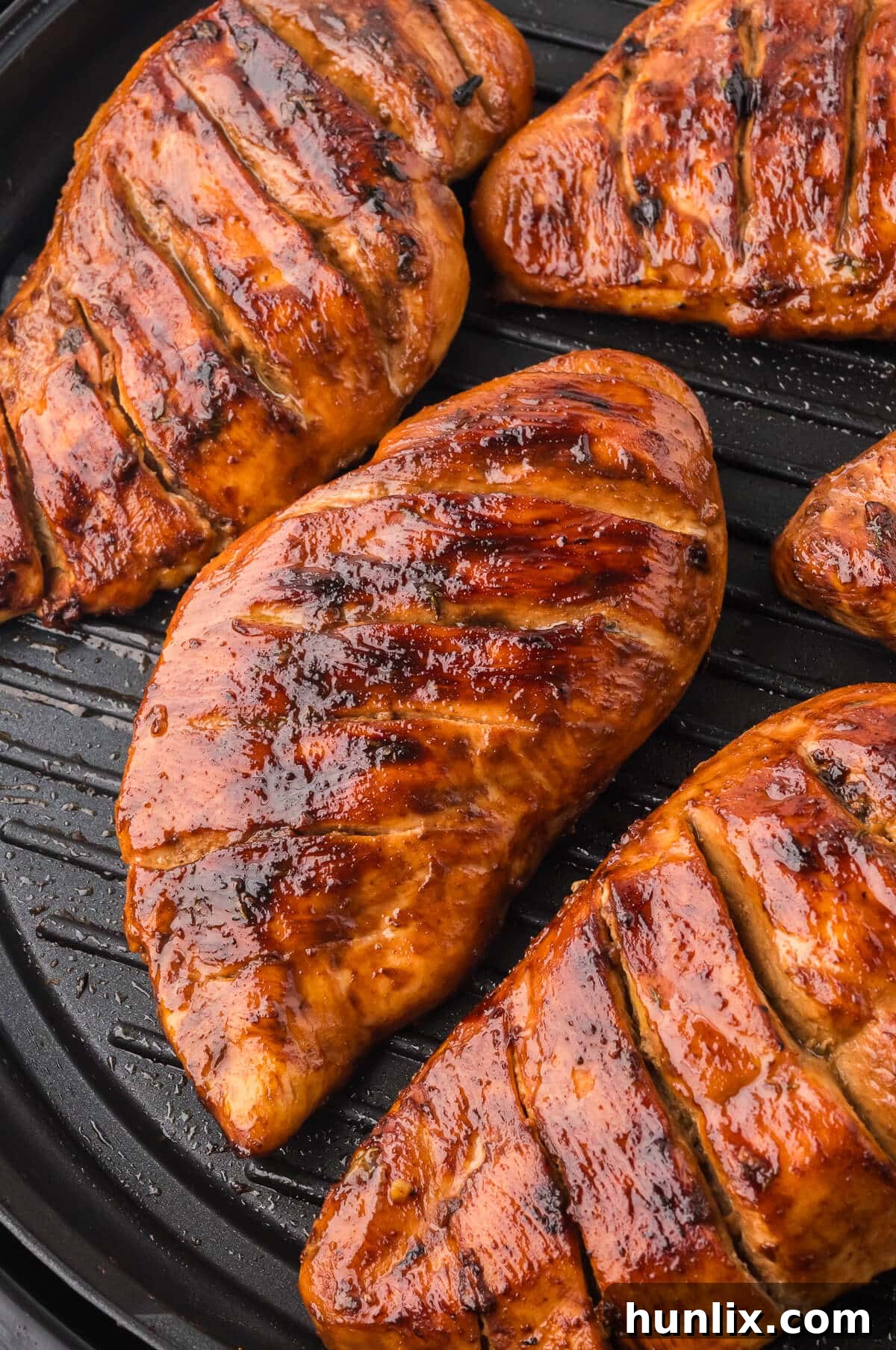 Maple dijon grilled chicken on a grill, perfectly charred and glistening with marinade.