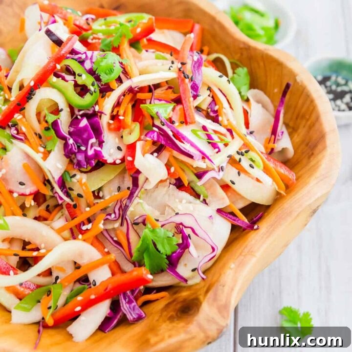 Colorful Thai Kohlrabi Noodle Salad featuring spiralized kohlrabi, red cabbage, red pepper, carrots, radishes, green onion, and a Thai-inspired vinaigrette.