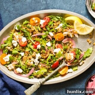 Really good Freekeh Salad with peppery arugula, juicy tomatoes, creamy goat cheese, and tangy pickled red onion, served warm or cold as a hearty whole grain salad.