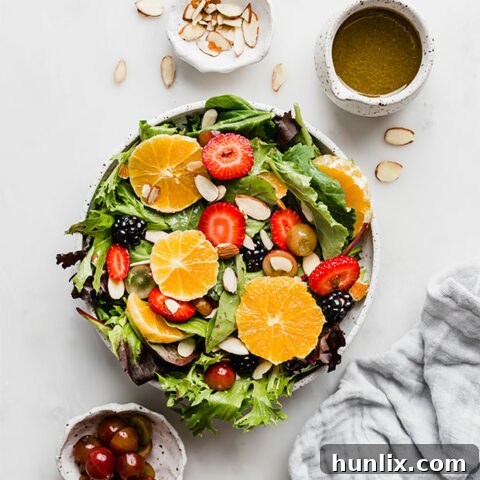 Citrus Summer Salad featuring fresh lettuce greens, an assortment of chopped fruits, crunchy nuts, and a vibrant citrus vinaigrette.