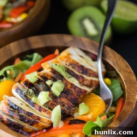 Spicy and sweet Asian-inspired main dish salad with vibrant peppers, oranges, carrots, and a zesty lime chili dressing.