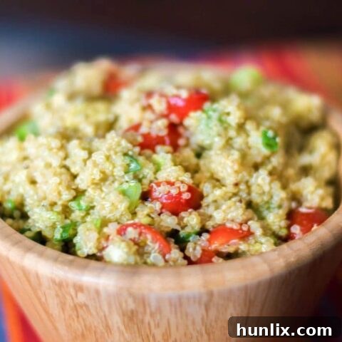 Healthy quinoa salad tossed with fresh avocado and tomatoes in a bright lime vinaigrette, making it light and delicious.