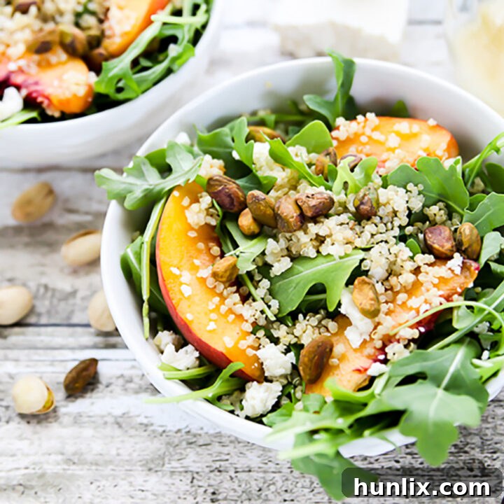 Flavor-packed arugula and quinoa salad with peppery arugula, protein-rich quinoa, sweet fresh peaches, crunchy pistachios, and savory queso fresco.