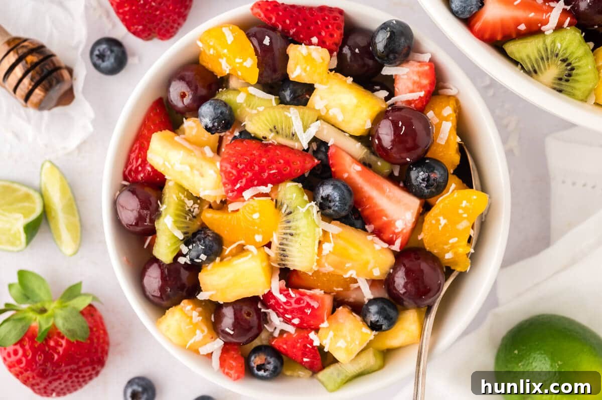 A close-up shot of a bowl of rainbow fruit salad, highlighting the fresh and colorful fruits.