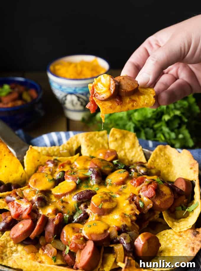 Close-up of Spicy Chili Nachos, highlighting the textures of chili, cheese, and crunchy tortilla chips.