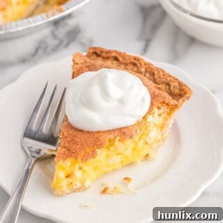 A slice of coconut pie on a plate with a fork, ready to be enjoyed.