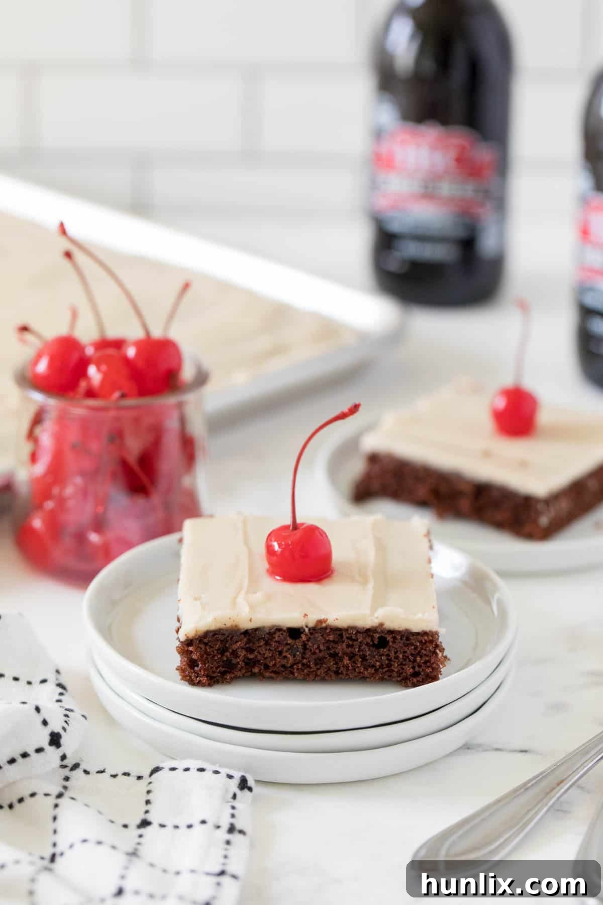 A single piece of root beer float sheet cake served on a pristine white plate, showcasing its fluffy chocolate cake layer and generous vanilla root beer frosting.
