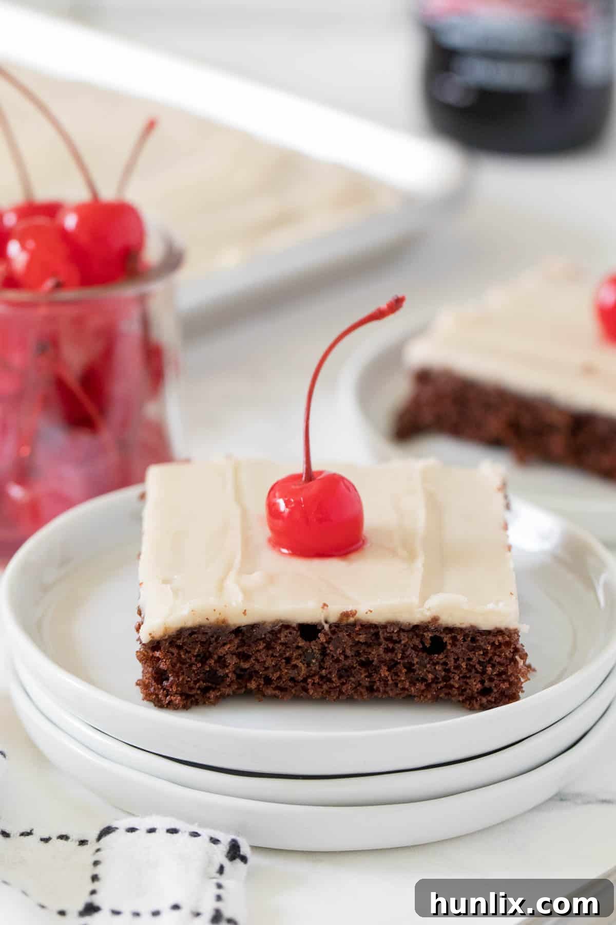 A perfectly sliced piece of root beer float sheet cake on a white plate, ready to be enjoyed, showing off its beautiful layers and toppings.
