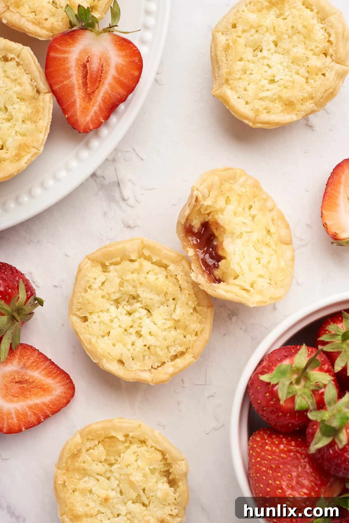 Beautifully arranged strawberry coconut tarts on a clean white surface, highlighting their delicate form.