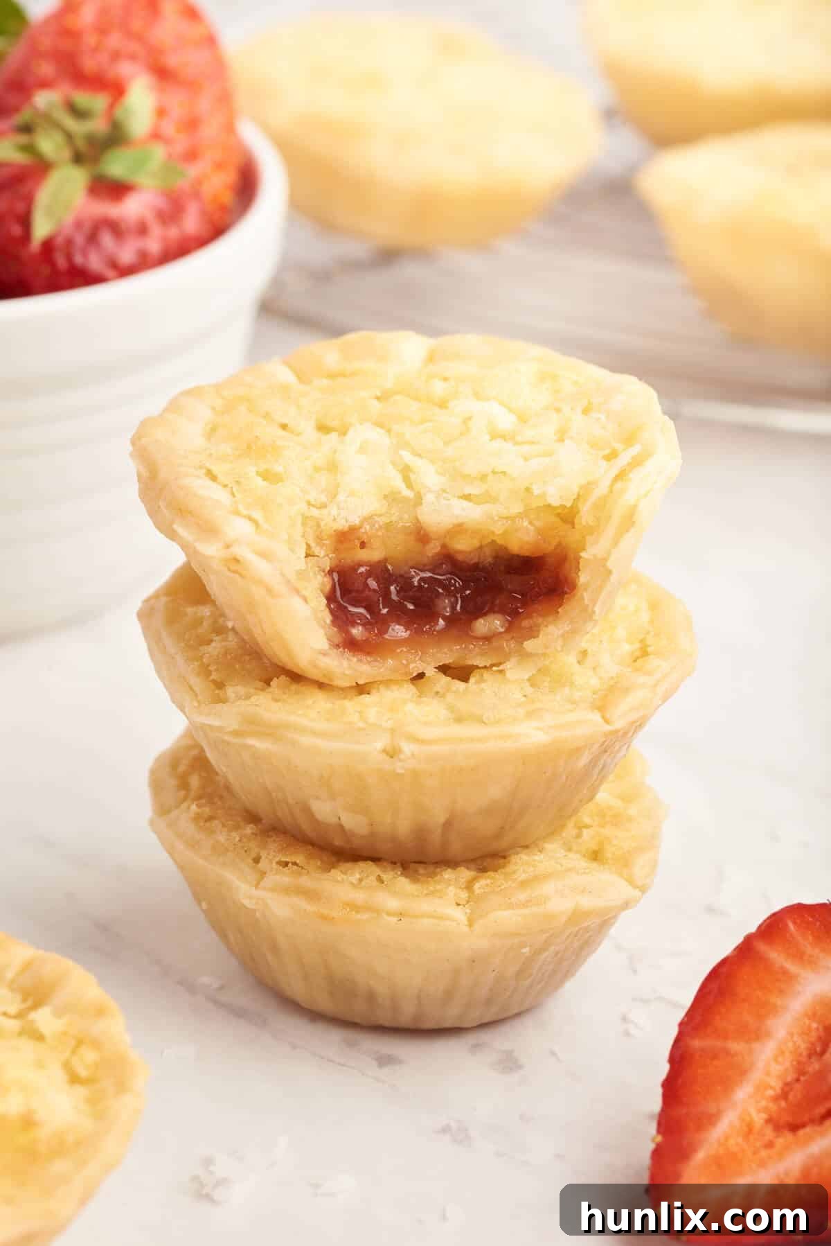A neatly stacked pile of strawberry coconut tarts, ready for serving or storage.