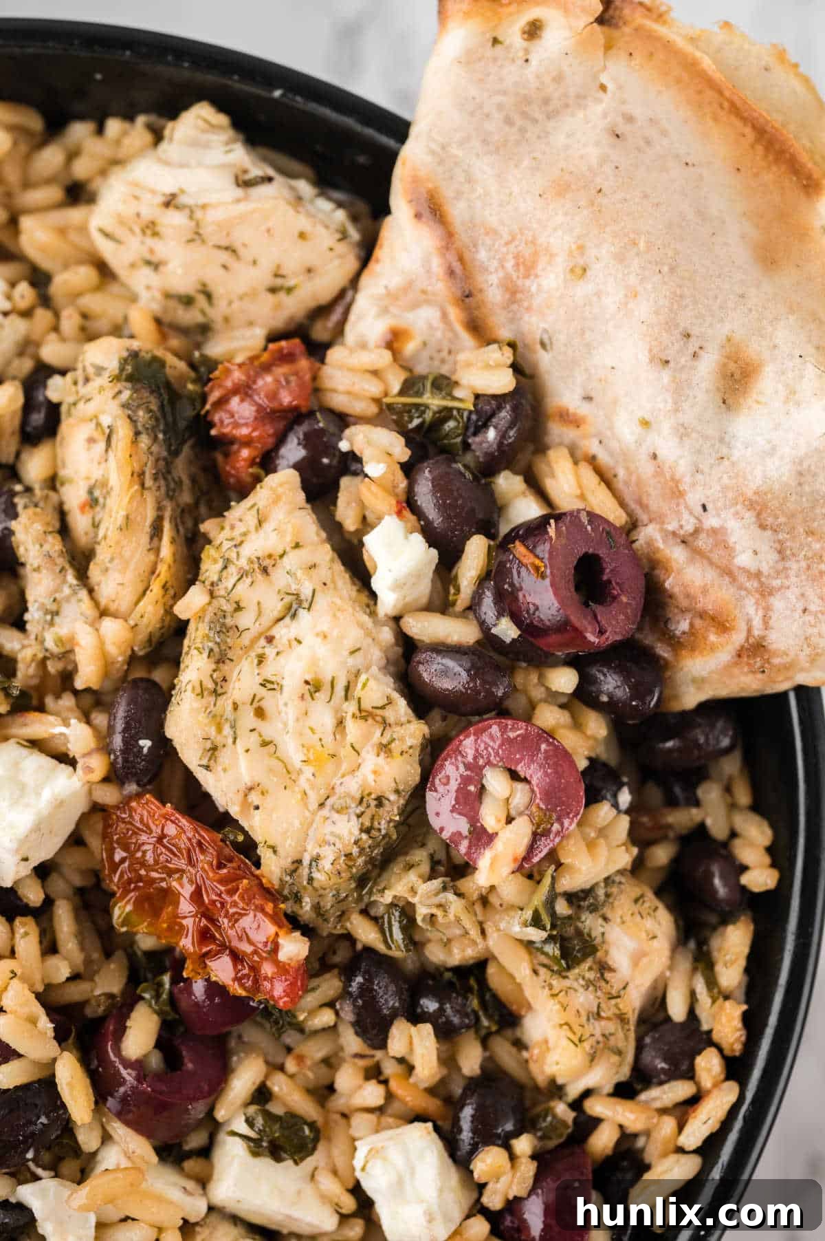 Vibrant Mediterranean Chicken Rice Bowl 11 Mediterranean chicken and rice bowl with a pita slice in it.