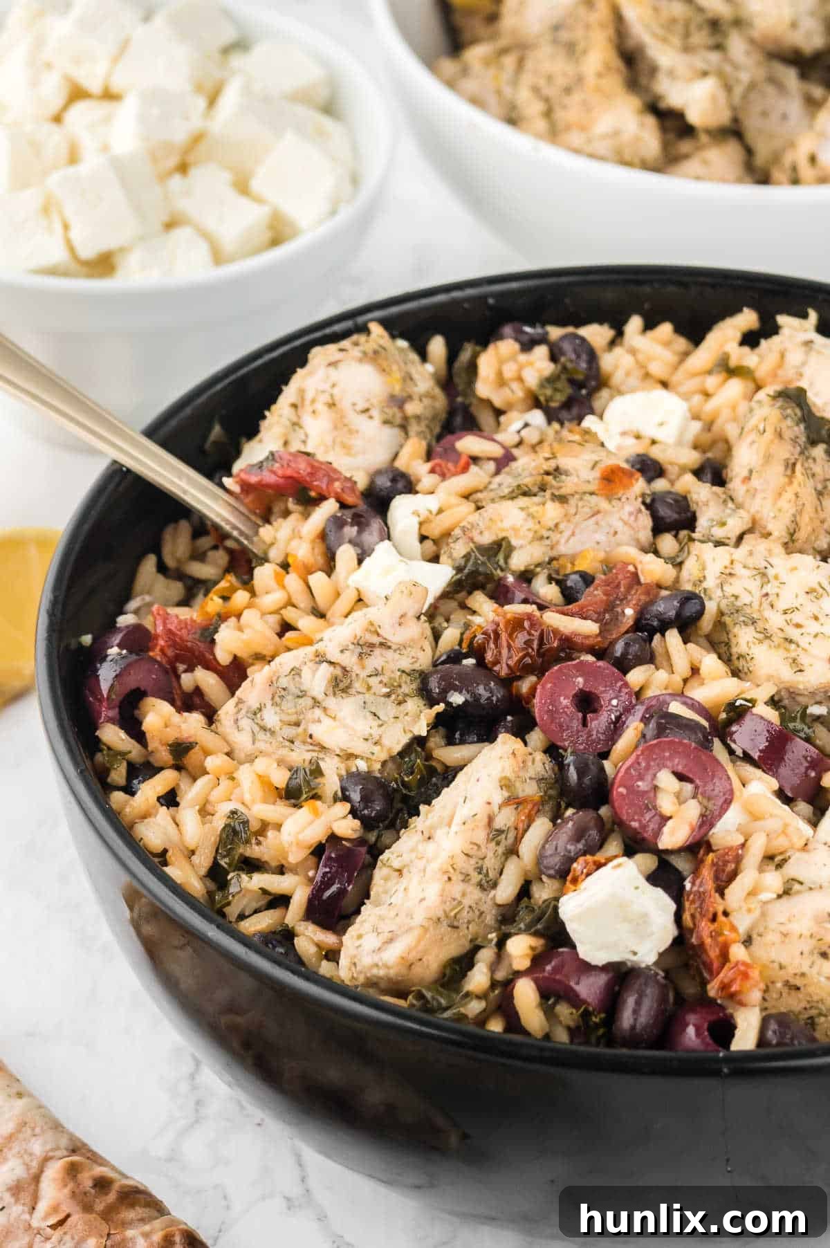 Vibrant Mediterranean Chicken Rice Bowl 12 Mediterranean Chicken and Rice Bowl with a spoon in it.