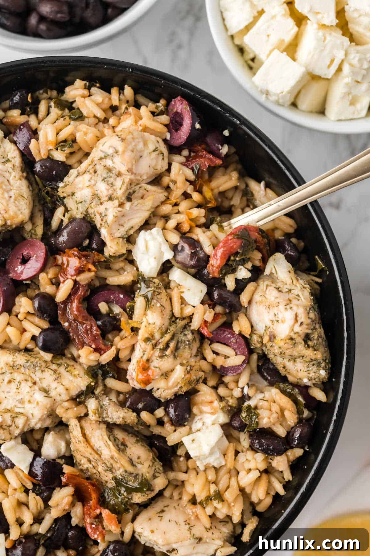 Vibrant Mediterranean Chicken Rice Bowl 10 Mediterranean chicken and rice bowl with a spoon.