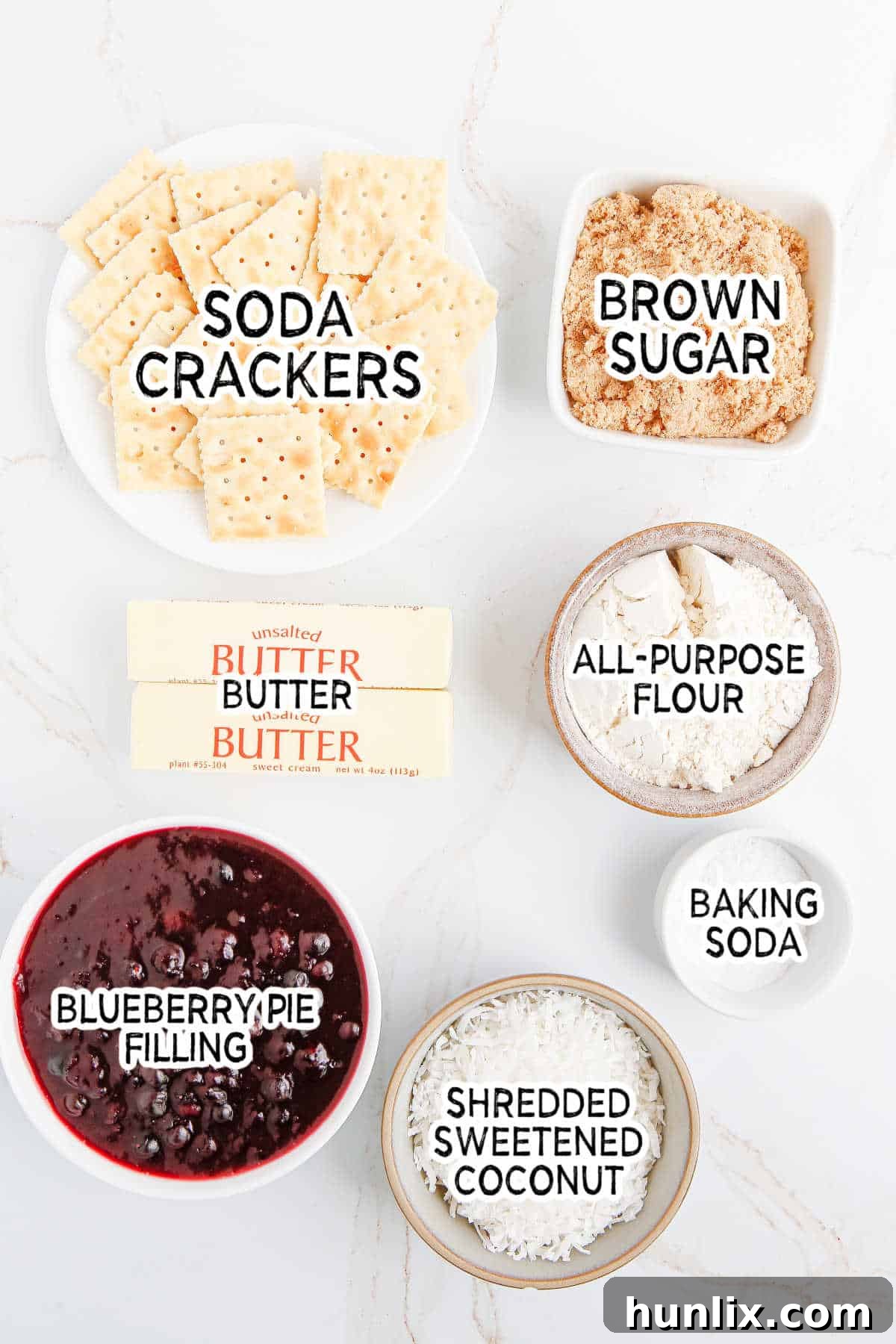 Blueberry Brittle Bake 3 Assortment of ingredients for Blueberry Crackle Cake, including crushed soda crackers, brown sugar, flour, butter, coconut, and blueberry pie filling.