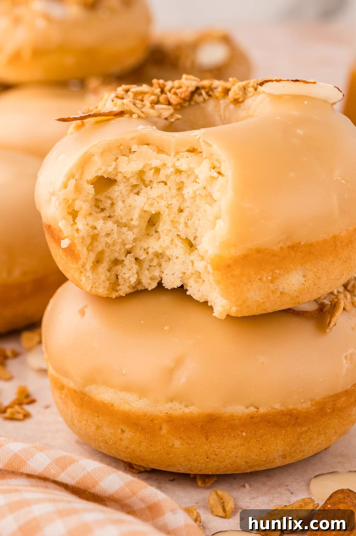 A stack of donuts with a bite out of one at the top.