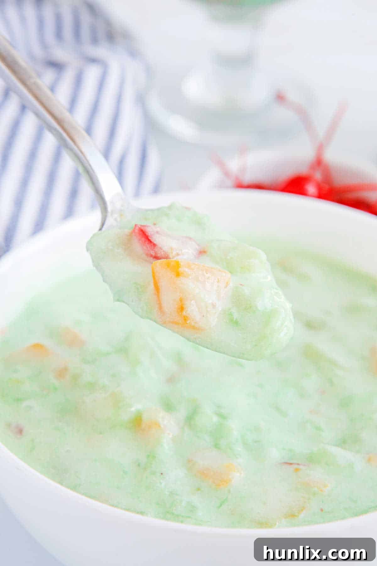 Vibrant Fruit Delight 9 Fruit cocktail dessert on a spoon.