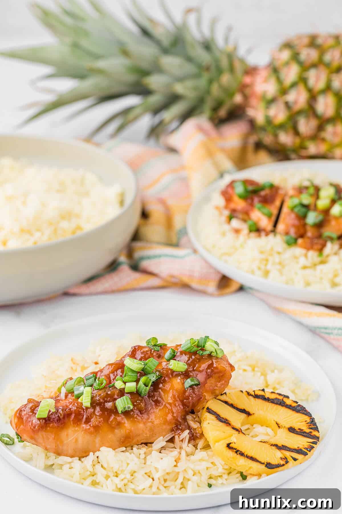 Island Style Chicken 7 A plate of Hawaiian chicken served with white rice and a side of grilled pineapple slices.