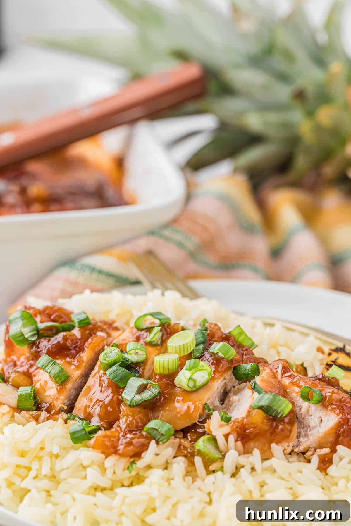 Island Style Chicken 8 Hawaiian chicken sliced into pieces and served over white rice in a bowl.