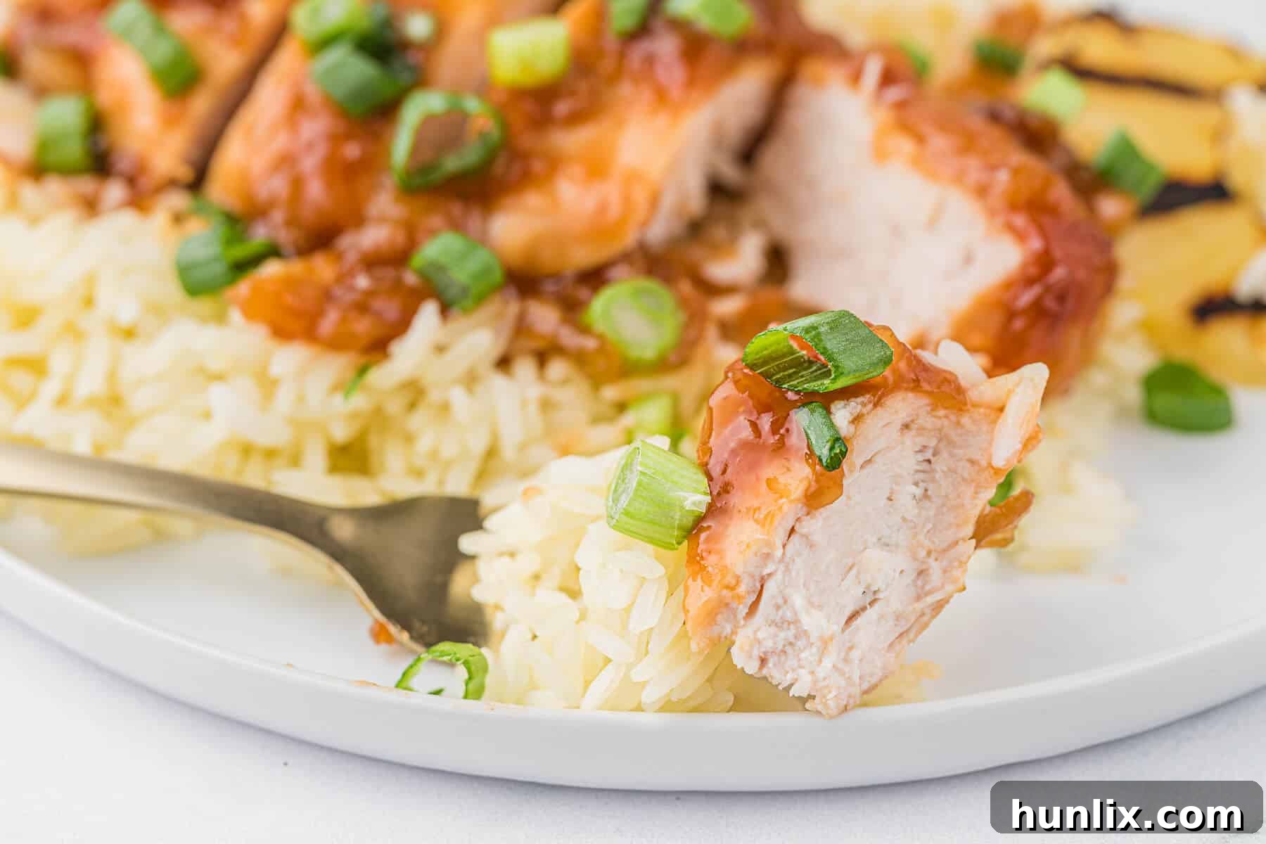 Island Style Chicken 9 A close-up of a piece of Hawaiian chicken on a fork, showing the saucy glaze.