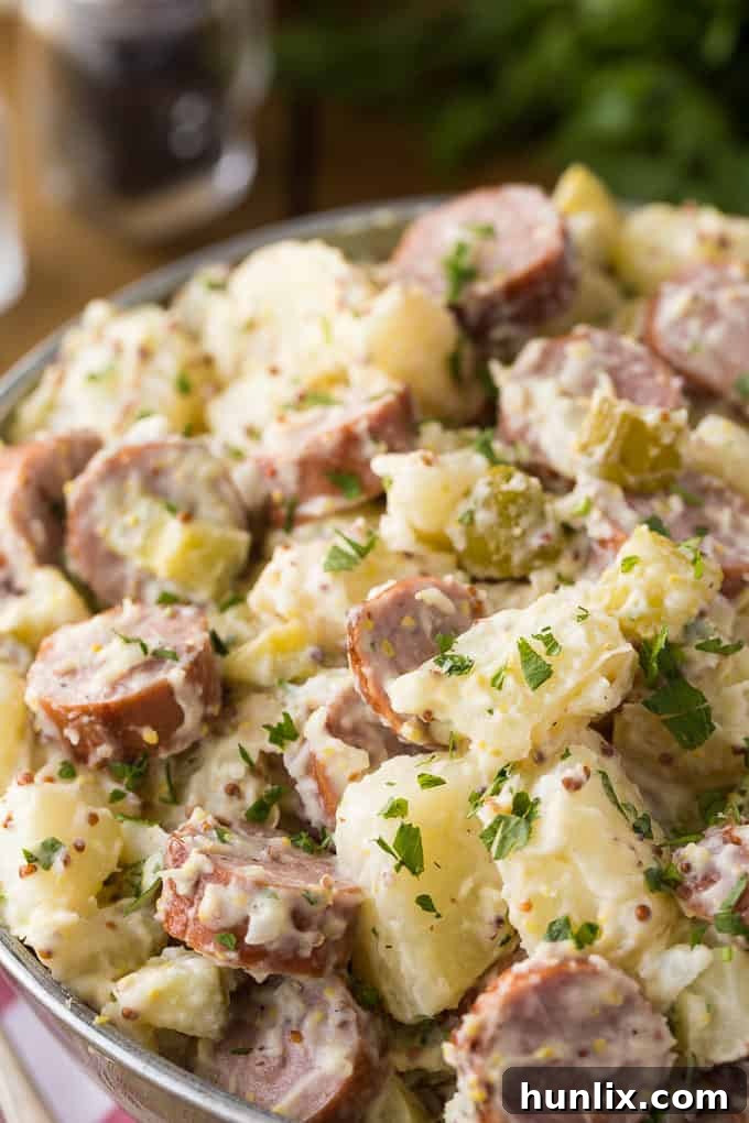 German Comfort Plate: Sausage and Potato Salad 5 A generous serving of German Sausage & Potato Salad, highlighting the hearty blend of potatoes, chicken sausage, and rich dressing.