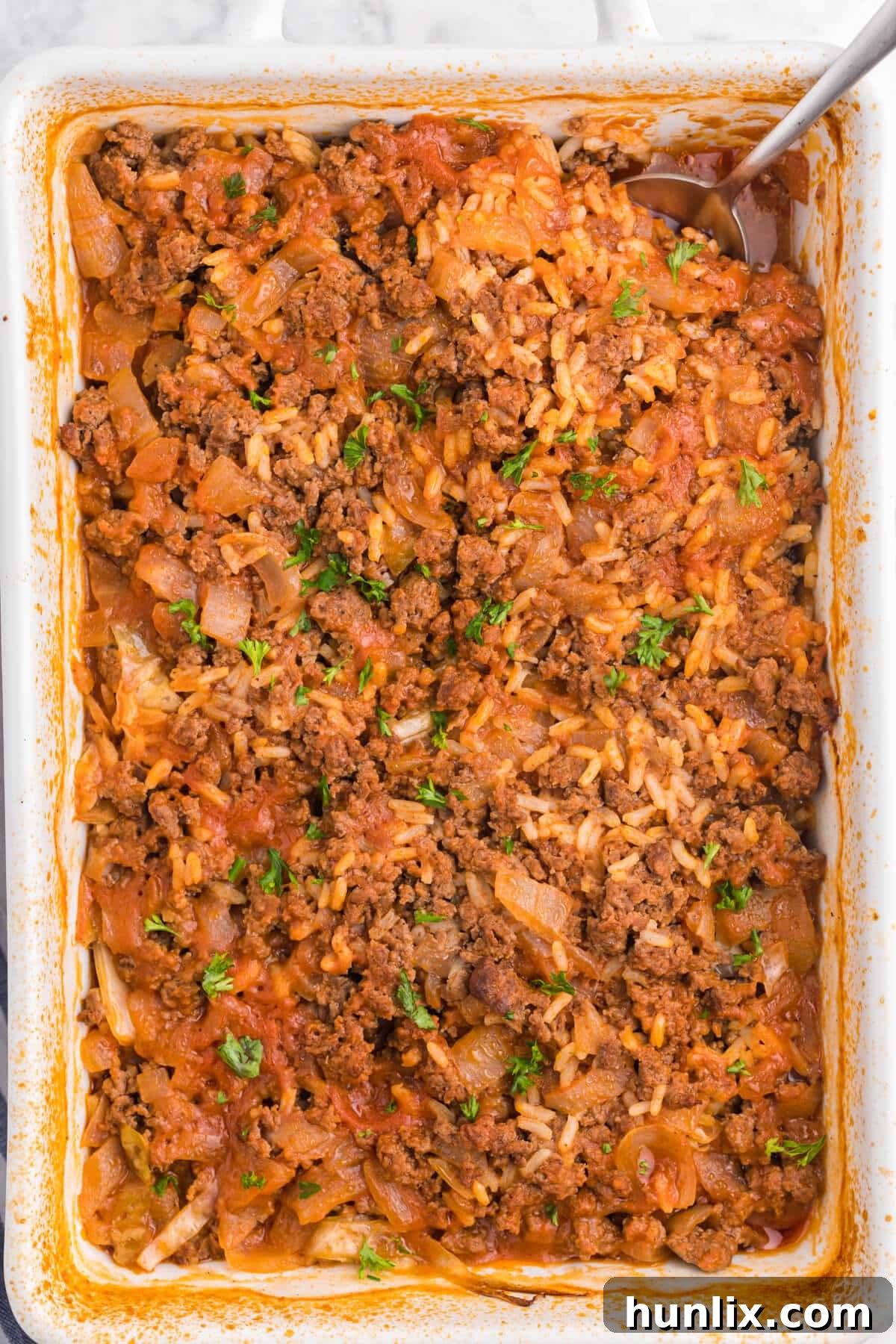 Hearty Cabbage Roll Casserole in a baking dish, ready to serve with a spoon, highlighting its comforting layers.