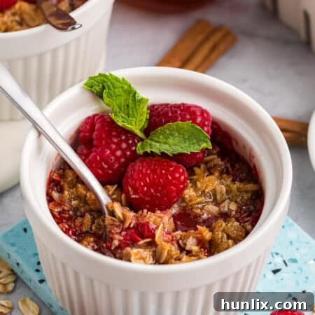 Raspberry crisp in a white ramekin with a spoon.