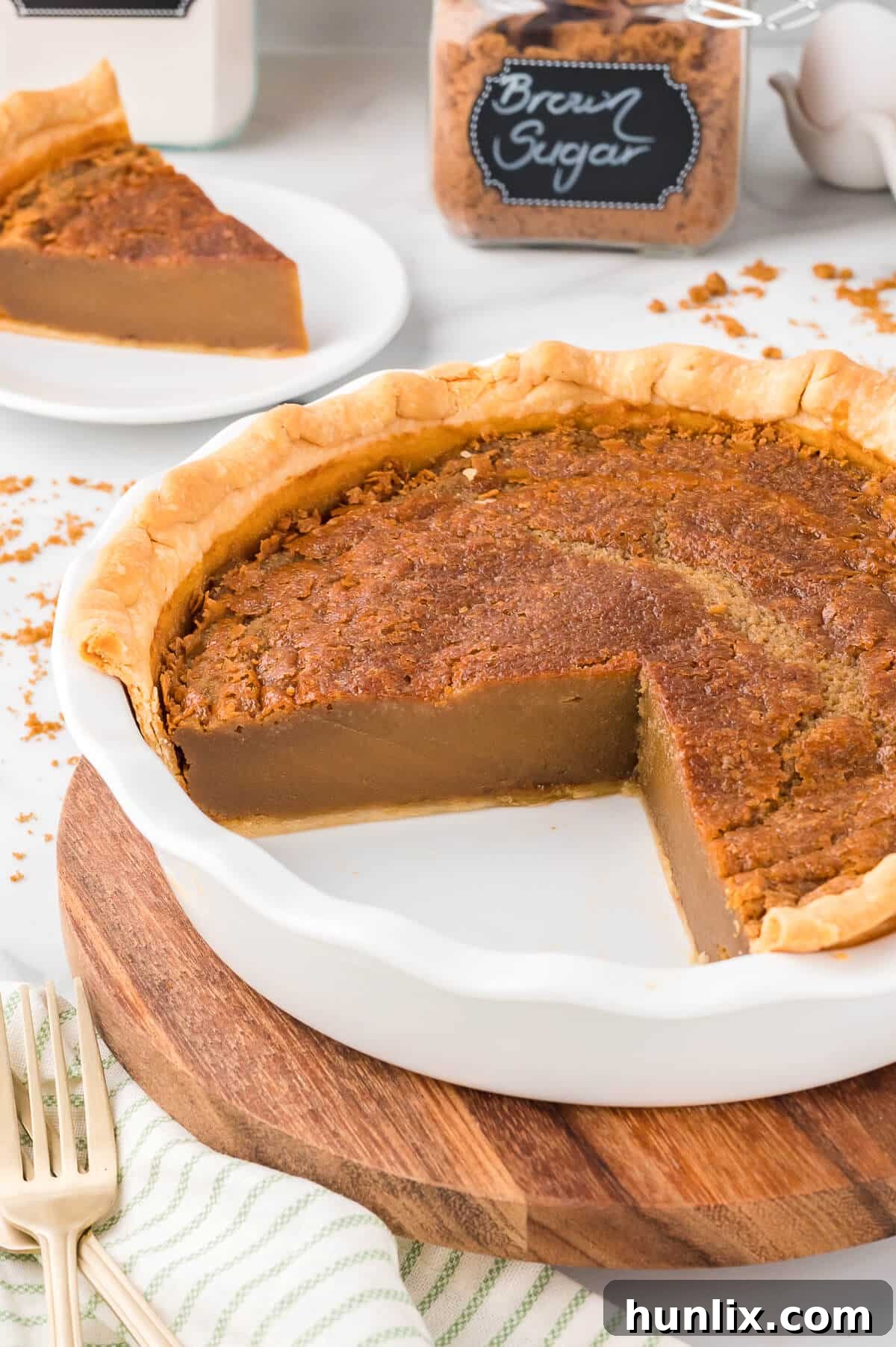 A beautifully baked sugar pie with several slices removed, showing the creamy, golden-brown filling and flaky crust.