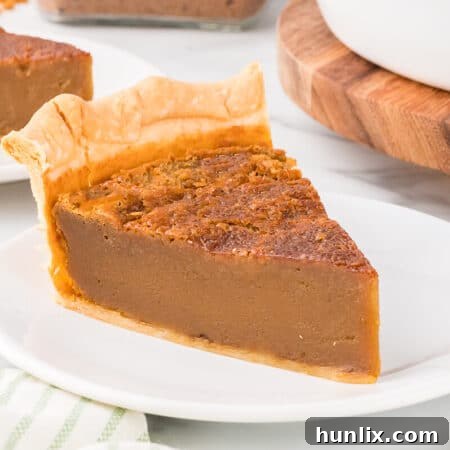 A slice of sugar pie on a plate, highlighting its golden crust and creamy filling.