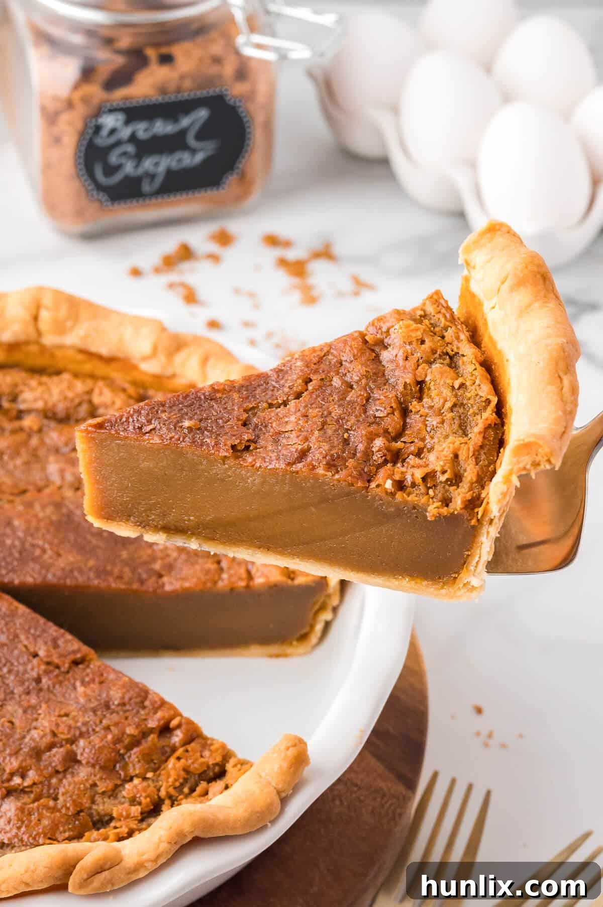 A pie server lifting a slice of sugar pie from the pan.