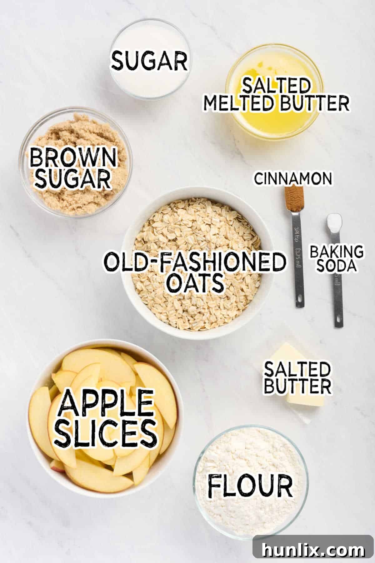 All the fresh ingredients for Apple Crisp Bars, neatly arranged on a pristine white marble counter, ready for preparation.