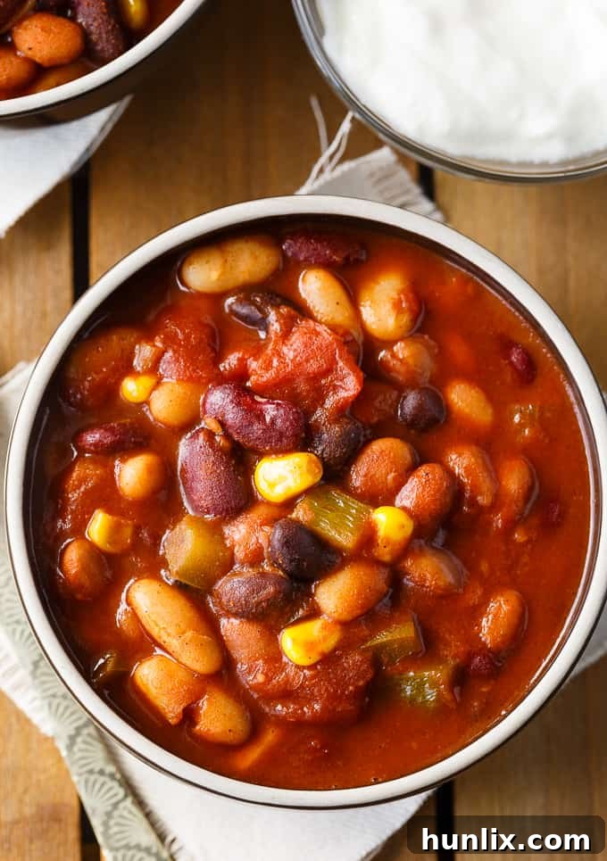 Hearty Bean Chili 3 Bean Chili - The heartiest meat-free chili recipe! Use four different kinds of canned beans in this comfort food classic with peppers, corn, and tomatoes.