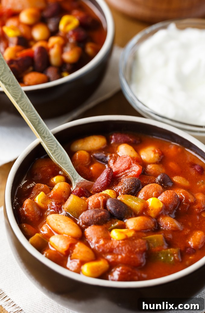 Hearty Bean Chili 4 Bean Chili - The heartiest meat-free chili recipe! Use four different kinds of canned beans in this comfort food classic with peppers, corn, and tomatoes.