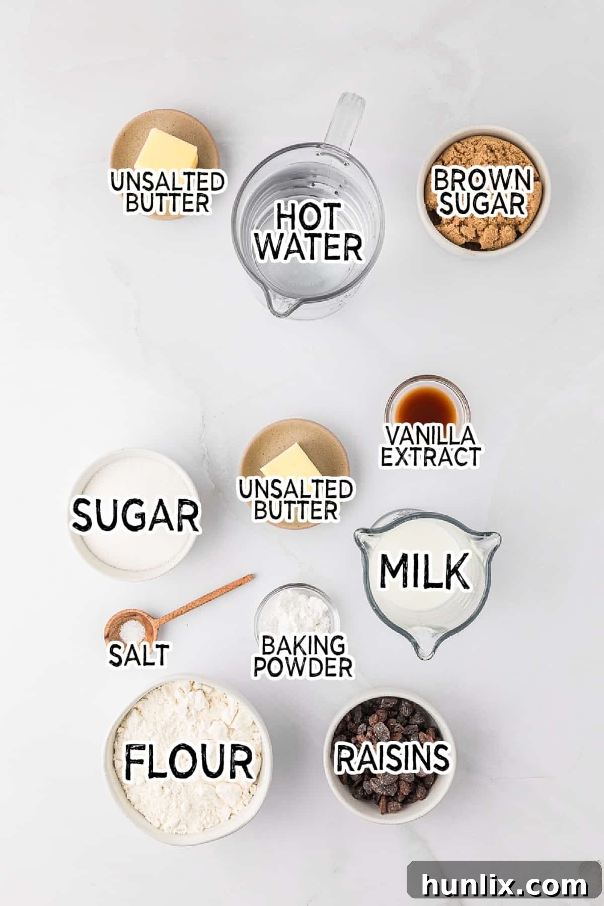 All the fresh ingredients laid out to make a classic Radio Pudding, including sugar, flour, butter, milk, raisins, and brown sugar.