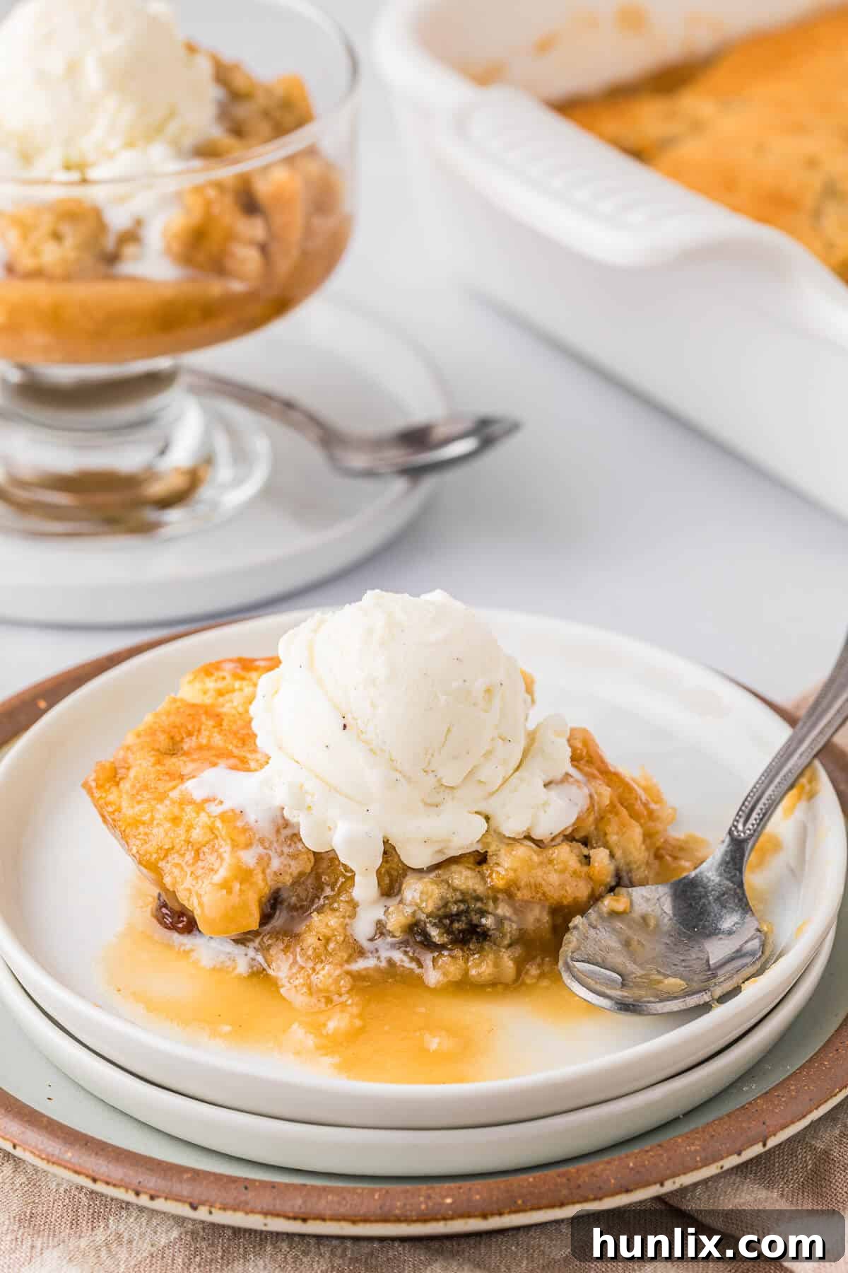 Radio pudding on a plate with vanilla ice cream, glistening with butterscotch sauce.