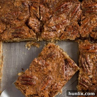 Maple Pecan Squares in a pan with a spatula.