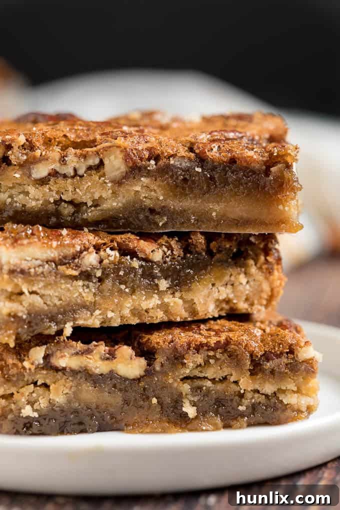 A neatly stacked collection of maple pecan squares, displaying their golden crust and rich topping.