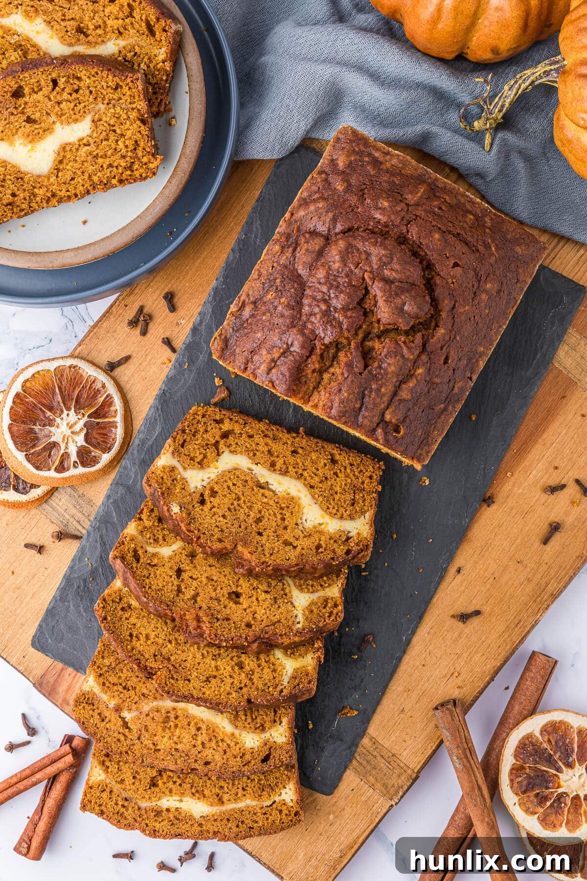 Slices of moist pumpkin ribbon bread showcasing a creamy cheesecake swirl.