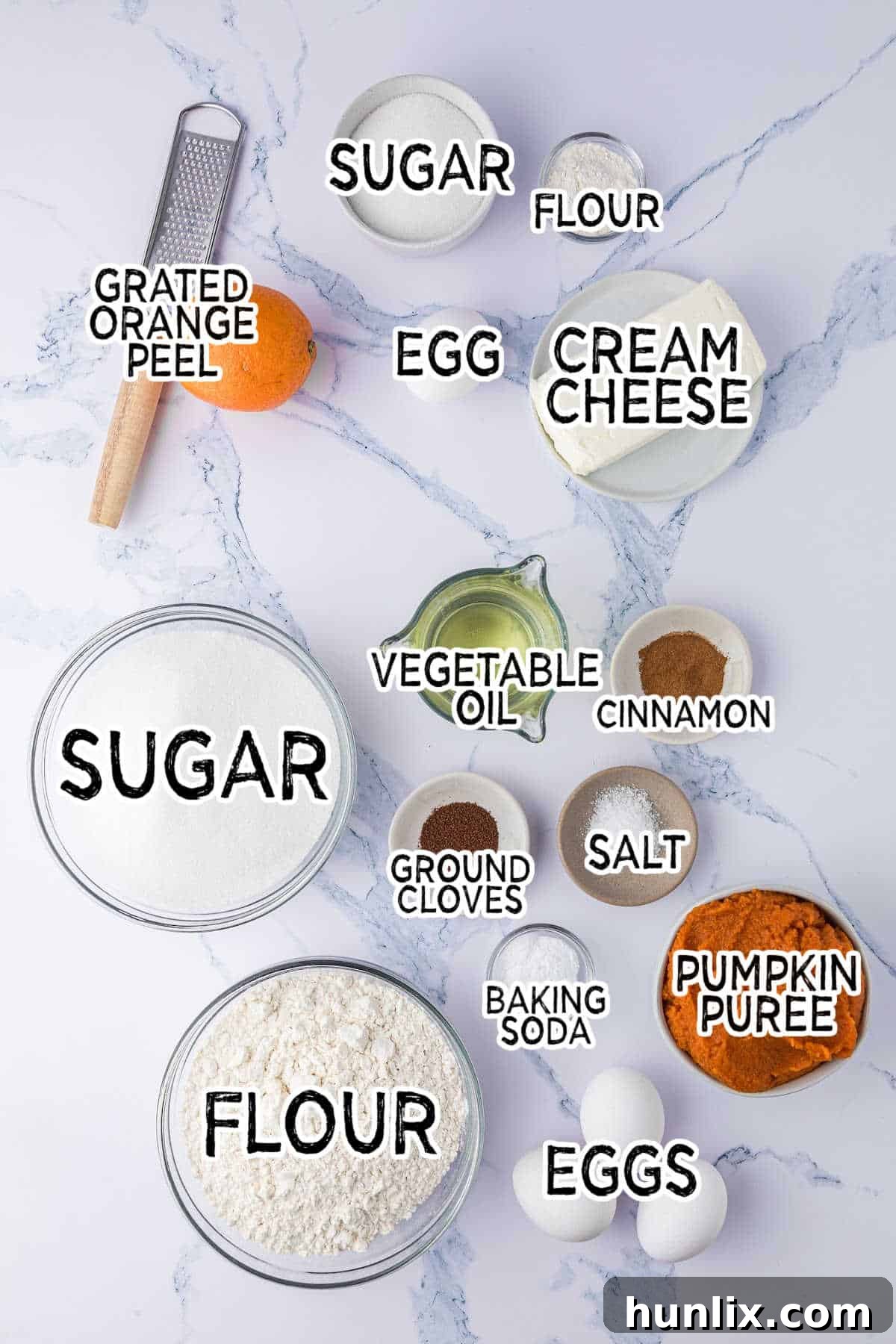 Assortment of fresh ingredients for pumpkin ribbon bread laid out on a white countertop.
