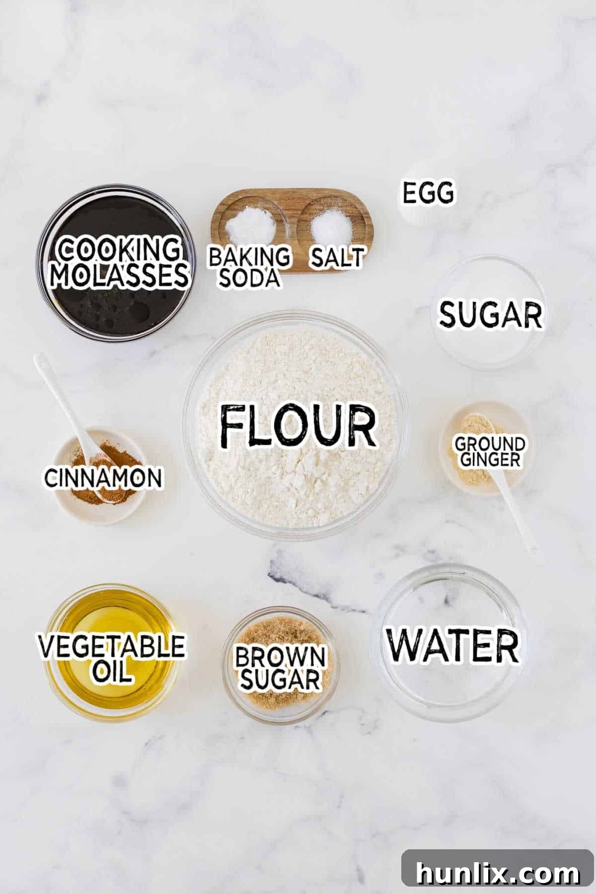 Collection of gingerbread muffin ingredients laid out on a marble counter.